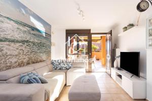 een woonkamer met een witte bank en een tv bij Sunset View La Tejita, by Nivariahost in Granadilla de Abona
