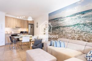 a living room with a large painting of the ocean at Sunset View La Tejita, by Nivariahost in Granadilla de Abona