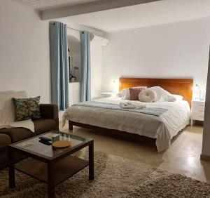 カルダス・ダ・ライーニャにあるCasa das Margaridasのベッドルーム1室(ベッド1台、ソファ、コーヒーテーブル付)