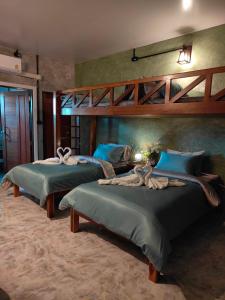 a bedroom with two beds with a woman laying on them at Smilingface guesthouse in Sukhothai