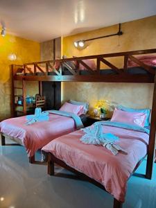 2 Betten in einem Zimmer mit 2 Etagenbetten in der Unterkunft Smilingface guesthouse in Sukhothai