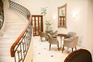 uma escada com cadeiras e uma mesa num quarto em Los Tallanes Hotel & Suites em Lima