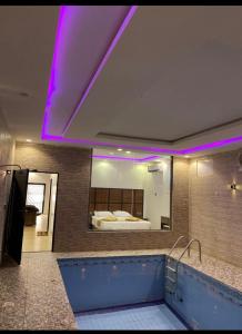 a bathroom with a tub and a bed in a mirror at شاليه أوركيد محايل عسير in Ar Raysh