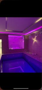 a bath tub with purple lighting in a bathroom at شاليه أوركيد محايل عسير in Ar Raysh