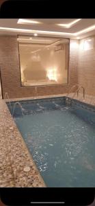 a large swimming pool with a large mirror in a bathroom at شاليه أوركيد محايل عسير in Ar Raysh