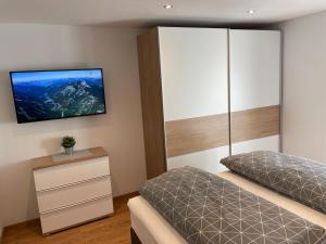 een slaapkamer met 2 bedden en een tv aan de muur bij Mountain View Appartements mit Blick WEITBLICK in Innsbruck