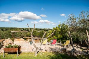 a backyard with chairs and a table and chairs at Sopra i Sassi - Villa & Trulli in Ostuni