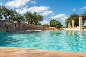 a swimming pool with a beach in the background at Sopra i Sassi - Villa & Trulli in Ostuni