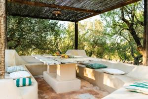 a table and chairs on a patio with trees at Sopra i Sassi - Villa & Trulli in Ostuni