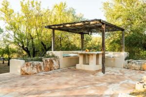 a picnic table under a pergola on a patio at Sopra i Sassi - Villa & Trulli in Ostuni