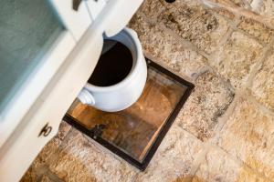 a white cup on the floor in a door at Sopra i Sassi - Villa & Trulli in Ostuni