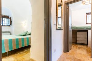 a small bedroom with a bed and a mirror at Sopra i Sassi - Villa & Trulli in Ostuni