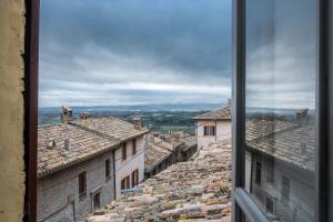 Blick auf die Dächer von Gebäuden aus dem Fenster in der Unterkunft Fontebella 46 in Assisi