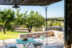 a patio with a table and chairs in a yard at Sopra i Sassi - Villa & Trulli in Ostuni