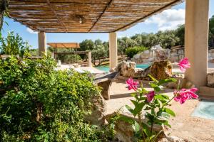 a patio with pink flowers and a swimming pool at Sopra i Sassi - Villa & Trulli in Ostuni