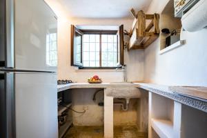 a kitchen with a sink and a refrigerator at Sopra i Sassi - Villa & Trulli in Ostuni