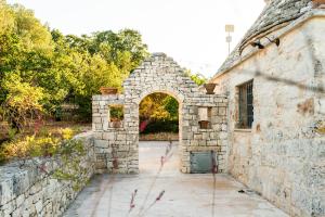 an entrance to an old stone building with an arch at Sopra i Sassi - Villa & Trulli in Ostuni