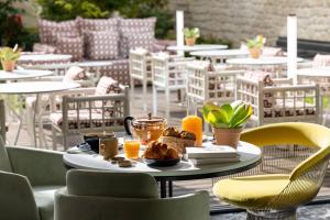 una mesa con un plato de comida en el patio en Quinzerie hôtel, en París