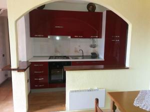 a kitchen with red cabinets and a sink at 2 bedrooms apartement with furnished terrace and wifi at Camigliatello Silano 2 km away from the slopes in Camigliatello Silano