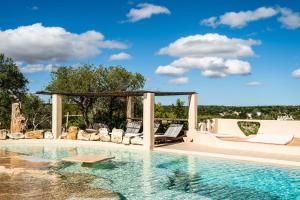 a swimming pool with chairs and a gazebo at Sopra i Sassi - Villa & Trulli in Ostuni