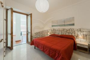 a bedroom with a red bed and a stone wall at Azzurro Mare a Seccheto - Goelba in Seccheto