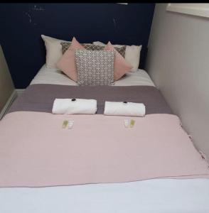 a white bed with pillows on it with three towels at The Hepburn Suite - In Central Bath in Bath