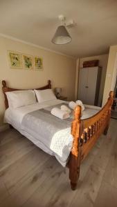 una camera da letto con un grande letto in legno con cuscini bianchi di Apartment 1, Regent Street a Bagenalstown