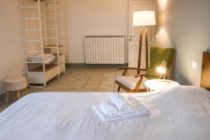 ein Schlafzimmer mit einem weißen Bett und einem Stuhl in der Unterkunft Fontebella 46 in Assisi