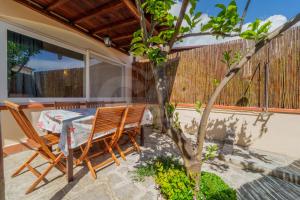a patio with a table and chairs and a tree at Azzurro Mare a Seccheto - Goelba in Seccheto