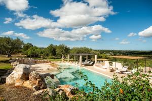 a pool in a backyard with a rock formations at Sopra i Sassi - Villa & Trulli in Ostuni