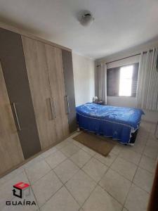 een slaapkamer met een blauw bed in een kamer bij House in Rio de Janeiro