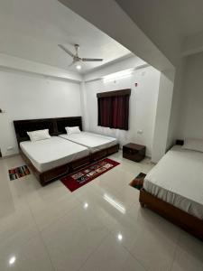 a bedroom with two beds and a window at UTSAV PALACE in Bodh Gaya