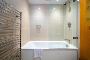 a white bath tub in a bathroom with a shower at GuestReady - One prime stay in the heart of London in London