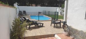 un patio con sillas y una piscina en Villa Conil, en Conil de la Frontera