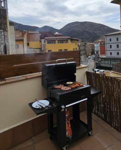 - un barbecue sur un balcon avec vue sur la ville dans l'établissement Apartamento Laia con máquina recreativa, à Ribes de Freser