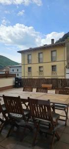 een grote houten tafel en stoelen voor een gebouw bij Apartamento Laia con máquina recreativa in Ribes de Freser