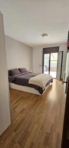 1 dormitorio con 1 cama grande y suelo de madera en Apartamento Laia con máquina recreativa en Ribes de Freser