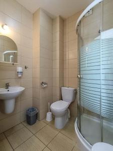een badkamer met een toilet, een wastafel en een douche bij Sami Swoi Kutno in Kutno