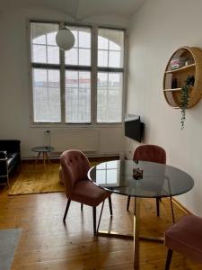 sala de estar con mesa de cristal y 2 sillas en berlincity, en Berlín