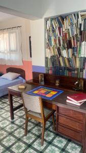 ein Zimmer mit einem Schreibtisch mit vielen Büchern in der Unterkunft El Pueblito in Cochabamba