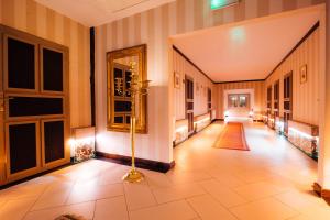 pasillo con suelo de baldosa y espejo en Pałac Wiechlice - Hotel, Restaurant, SPA, en Szprotawa