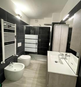 ein Badezimmer mit einem Waschbecken, einem WC und einem Waschbecken in der Unterkunft Sun shine in Cesano Boscone
