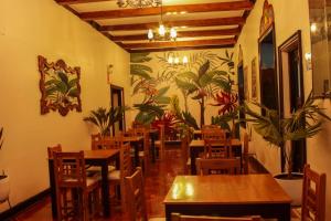 Casona Valdelirios Hotel في اياكوتشو: مطعم بطاولات وكراسي خشبية وجدارية