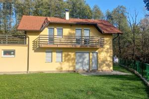 a yellow house with a balcony on a yard at Kuća za odmor- Milošev Konak Banja Luka 