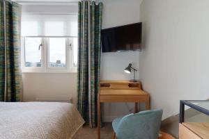 a bedroom with a desk and a bed and a television at The Oxford Lodge Balliol Room in Oxford