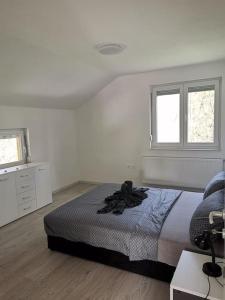 um quarto branco com uma cama e 2 janelas em Kuća za odmor- Milošev Konak Banja Luka 