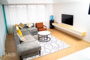 a living room with a couch and a table and a tv at Laurel Living 2-Bedroom apartment in Nairobi
