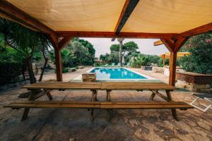 a pavilion with a picnic table and a swimming pool at Private Villa in Naxxar