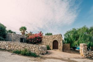 a stone building with a gate and a stone wall at Private Villa in Naxxar