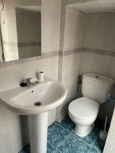 a bathroom with a white sink and a toilet at Alojamiento Orellana in Orellana la Vieja +17 photos